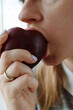 Close-up of a woman's mouth eating ripe peach a lunchtime, a healthy fresh snack for healthy people.