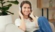Portrait, happy woman and music headphones in home living room on sofa for relax, streaming or listening to audio. Face, radio and smile of girl on couch for podcast, kpop or sound on tech in Italy