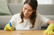 Woman, cleaning and table in house with smile for housework, spray and cloth for furniture. Female cleaner, or worker with container and soap for washing, hospitality service in home or apartment