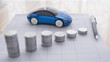 © hunterpic2013 - Stacks of coins on the table representing a falling or devaluing graph. Car price . Miniature car on the table
