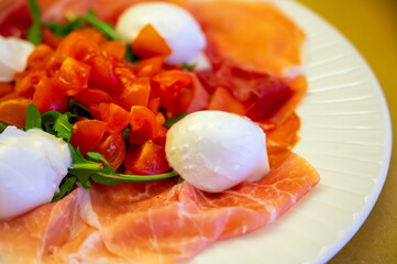 Cuisine of Emilia-Romagna region, Caprese salad with Prosciutto crudo, prosciutto di Parma, mozzarella cheese and tomatoes, lunch in Parma, Italy