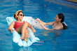 © DragonImages - Mother and teen daughter spending sunny day in swimming pool