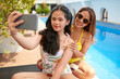 © DragonImages - Teenage girl taking selfie with mother at swimming pool