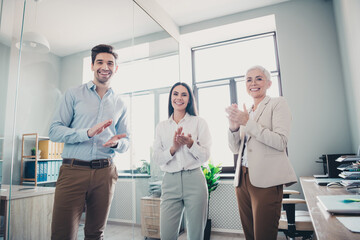 Wall Mural - Photo of three business people support clapping hands in modern office