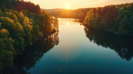 Wall Mural - A calm lake that reflects the enchanting colors of the sunrise, surrounded by dense forests in spring