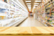 Empty wood table top with supermarket blurred background for product display