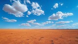 Arid desert landscape with blue sky and clouds