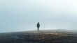 Person standing alone in a foggy landscape