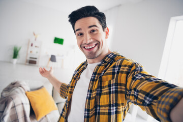 Canvas Print - Photo of cheerful positive guy dressed plaid shirt recording video showing apartment indoors room home house