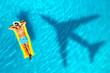 © New Africa - Shadow of airplane and happy man on inflatable mattress in swimming pool, top view. Summer vacation