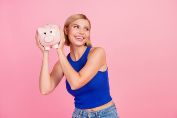 Sticker - Photo of pretty young woman shake money bank pig look empty space wear blue top isolated on pink color background