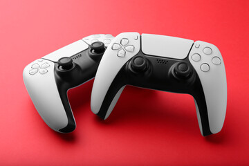 Two wireless game controllers on red background