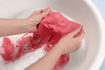 Canvas Print - Woman washing baby clothes in basin, closeup