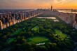 A stunning aerial view of Central Park at sunset, with the New York City skyline in the background and lush greenery spread across its vast expanse. The sun casts long shadows over the trees as it set