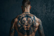 Lion tattoo on the back of man on dark background