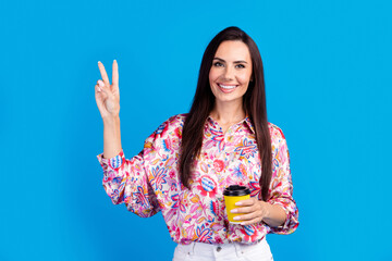 Poster - Photo of dreamy positive lady dressed print blouse enjoying hot beverage showing v-sign isolated blue color background