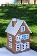 Beautiful toy two-story house with blue light in the windows on a background of green grass