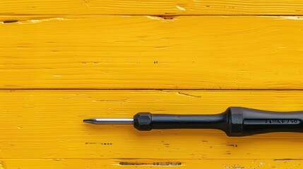 Sticker - A screwdriver laying on a yellow wooden surface. Suitable for hardware or DIY projects