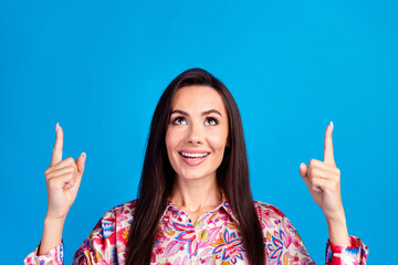 Wall Mural - Photo of excited dreamy lady dressed print blouse looking pointing two fingers up emtpy space isolated blue color background