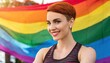 © Marko - Strong and muscular lesbian, proud woman with a smile and crossed muscle arms and short hair on a colourful lgbt background