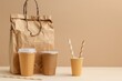 Two cups of coffee and a brown paper bag, perfect for coffee shop promotions