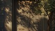   A tree's shadow graces the door of a building, where a bench and a potted plant are positioned invitingly