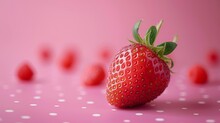   A Macrodose Of A Ripe Strawberry Against A Pink Backdrop, Displaying Tiny White Specks At The Base