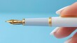   A tight shot of a hand clutching a pen with a golden nib at its tip