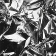   A monochrome image of disorganized tin foil scraps, gleaming metallically