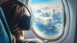 Young woman with headphones listening to music on the background of the clouds in the plane
