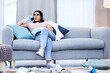 © peopleimages.com - Woman, phone call and relax on sofa in living room for talking, gossip and networking. Housewife, technology and delay household chores on couch for communication, conversation and connection