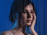Fototapeta Tęcza - Creative studio portrait of young beautiful woman with foreground made of water drops in blue tones. Drops are in focus intentionally