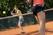Two competitive female tennis players engage in an intense match.	

