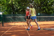 After the practice, these two female tennis players clean the court, removing any traces of their game and leaving it ready for the next training.	