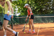 After the practice, these two female tennis players clean the court, removing any traces of their game and leaving it ready for the next training.	