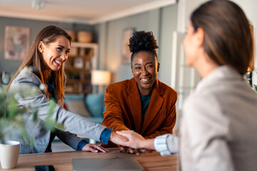 Wall Mural - International business women showing unity with putting their hands together on top of each other. Concept of teamwork.