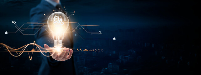 Wall Mural - software development: businessman holding creative light bulb with digital networking and software d