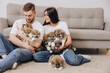 © anatoliycherkas - Beautiful smiling happy couple playing with akita inu puppies in dog house or shelter