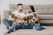 © anatoliycherkas - Beautiful smiling happy couple playing with akita inu puppies in dog house or shelter