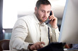 © peopleimages.com - Man, office and telephone call with communication, computer and press button for voip tech in night. Person, agent or financial advisor at help desk for consultation, crm and dial at contact center