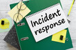 Incident response text on the page on a green folder near stickers on the work desk.