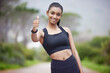 Active, woman and thumbs up for fitness in outdoors or portrait as runner for exercise or training for race. Indian, female person and sports for cardio, health and wellness for achievement of goal