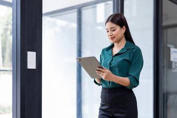 Wall Mural - Young asian woman, professional entrepreneur standing in office clothing, smiling and looking confident, office background