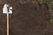 Brown soil ground texture background with copyspace and shovel on garden bed in farm garden. Organic farming, gardening, growing, agriculture concept
