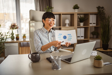 Wall Mural - Mature japanese woman hold document and have consultation via video call