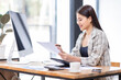 © David - Portrait of an Asian businesswoman smiling while sitting at her desk.doing planning analyzing the financial report, business plan investment, finance analysis concept.