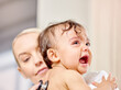 © peopleimages.com - Sick baby, crying and medical woman with stethoscope for check up, healthcare and illness in family clinic. Child, female physician and hospital bed for upset kid, pediatrician and unwell infant