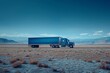 A blue truck cruises down a desert highway under a vast sky