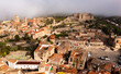 Aerial view of historic area of Trujillo overlooking central square surrounded by residential houses with medieval castle and Church of Santa Maria la Mayor in background in haze on spring day, Spain