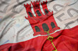 waving colorful national flag of gibraltar on a euro money banknotes background. finance concept.
